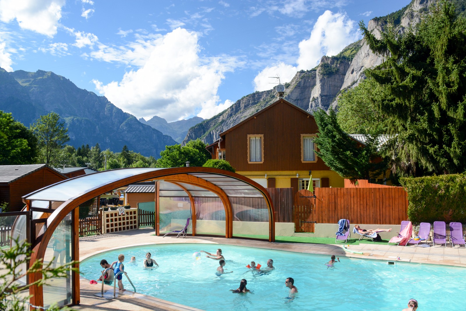 Une piscine extérieure avec terrasse et transats par beau temps