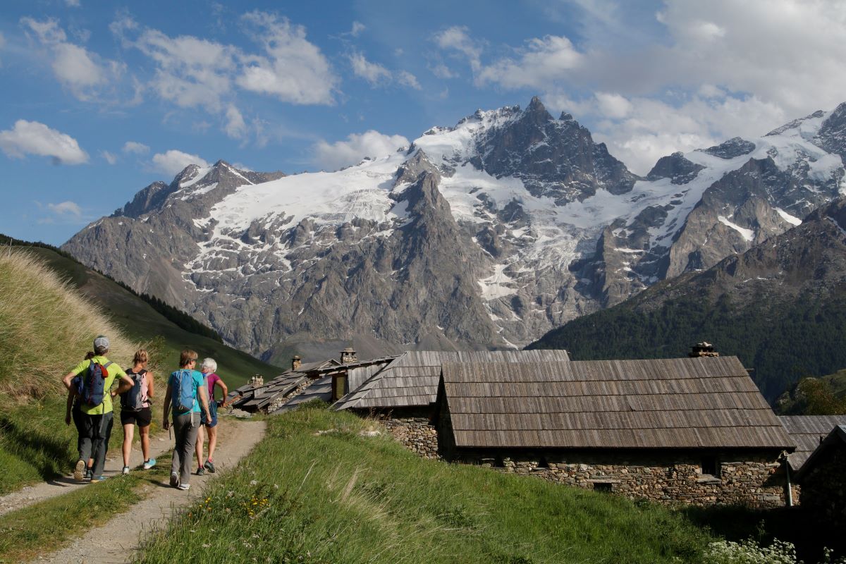 Randonneurs arrivant au hameau du Rivet de la Cime avec la Meije en toile de fond